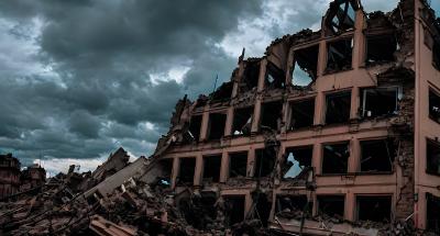 Zertrümmertes Gebäude vor dunkelgrau bewölktem Himmel