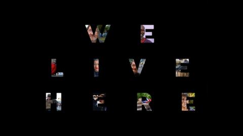 Logo von 'We Live Here' Schriftzug "We Live Here" vor schwarzem Hintergrund